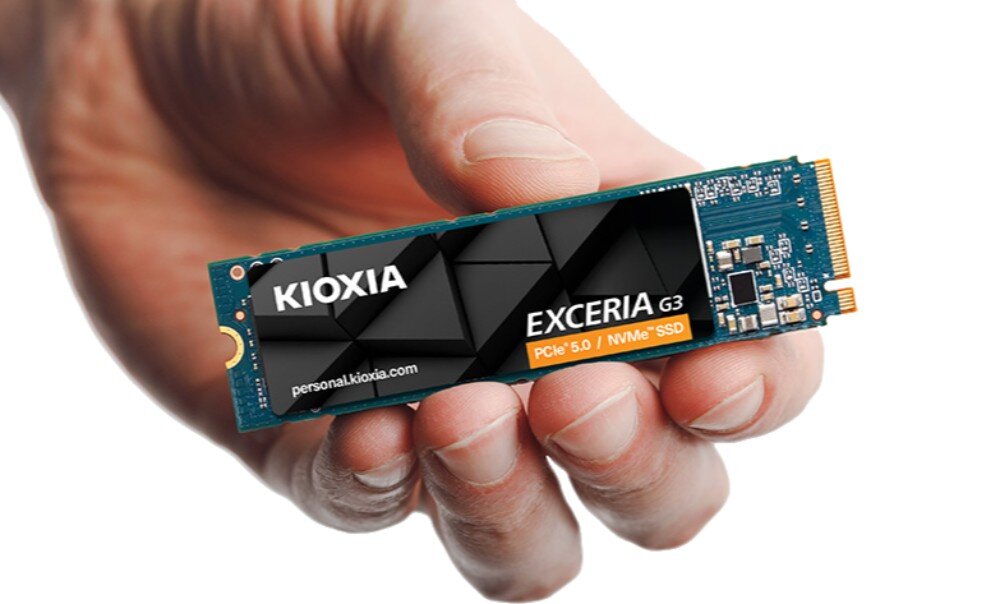 Dysk KIOXIA Exceria G3 Ludzka dłoń trzymająca poziomo dysk SSD M.2 na jasnym, jednolitym tle, prezentując jego strukturę i etykietę z napisem 'Exceria G3', interfejs, prędkość, pojemność
