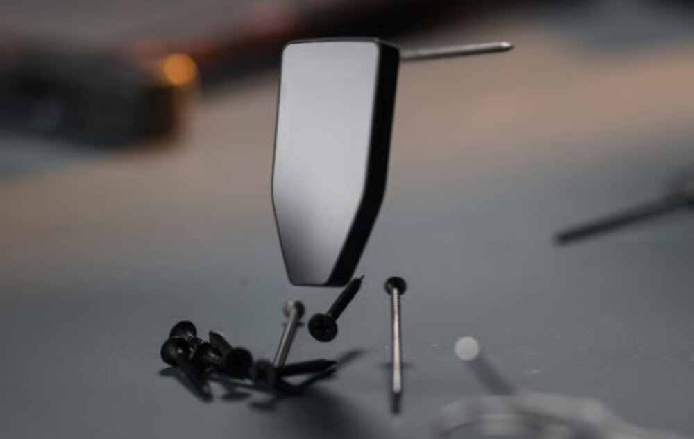 Zbliżenie na unoszący się korpus portfela sprzętowego otoczony śrubami na ciemnym tle warsztatowym – Ekran dotykowy pokryty szkłem Gorilla Glass 