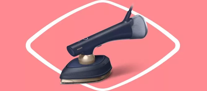 Na różowym tle znajduje się ciemnoniebieska parownica do ubrań z widocznym logo \'PHILIPS\'. Urządzenie ma złoty element i przezroczystą końcówkę parową.