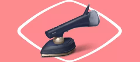 Na różowym tle znajduje się ciemnoniebieska parownica do ubrań z jasnoszarymi i złotymi elementami. Widoczne jest logo \'PHILIPS\' na urządzeniu.