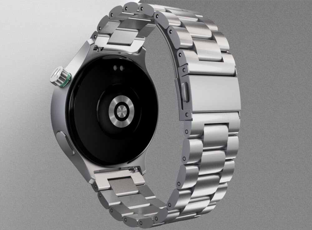 Obraz przedstawia smartwatch z metalową bransoletą i okrągłą kopertą. Tło jest jednolite, szare.