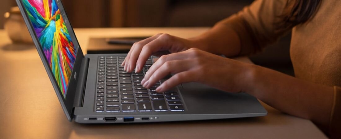Osoba korzysta z laptopa NTT Book, prezentując porty USB, HDMI i audio podczas codziennej pracy mobilnej