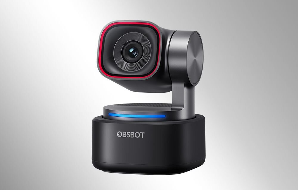 Kamera internetowa z obrotową głowicą, czarna z czerwonym akcentem wokół obiektywu. Na podstawie widoczne jest logo \'OBSBOT\'.