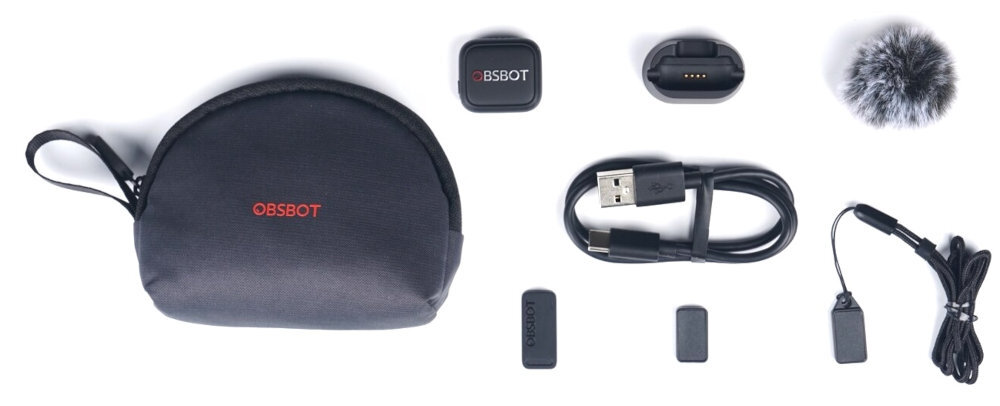 OBSBOT Vox SE stacja dokująca do ładowania z portem USB-C, osłona przeciwwietrzna, magnetyczny klips do mocowania mikrofonu, magnetyczny klips tylny, magnetyczna smycz na szyję, kabel zasilający USB-A do USB-C, etui transportowe oraz dokumentacja.