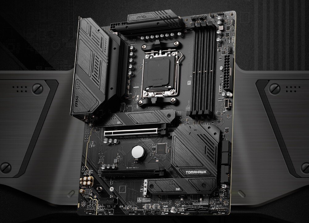 Komputer MAD DOG Powered By MSI FORGE112R-A04DR32 Czarna płyta główna z rozbudowanymi radiatorami, gniazdem procesora, czterema bankami pamięci i oznaczeniami 'MAG' oraz 'TOMAHAWK'