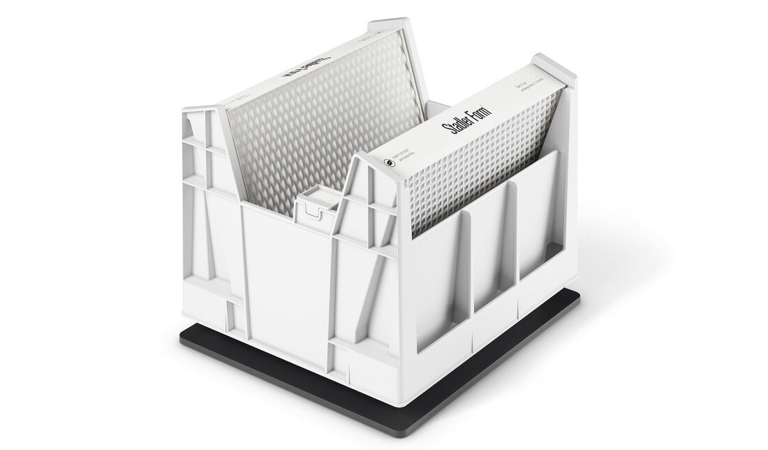 Biały nawilżacz ewaporacyjny z widocznym logo \'Stadler Form\' na górnej części. Urządzenie ma prostokątny kształt z otwartą konstrukcją i znajduje się na ciemnej podstawie.