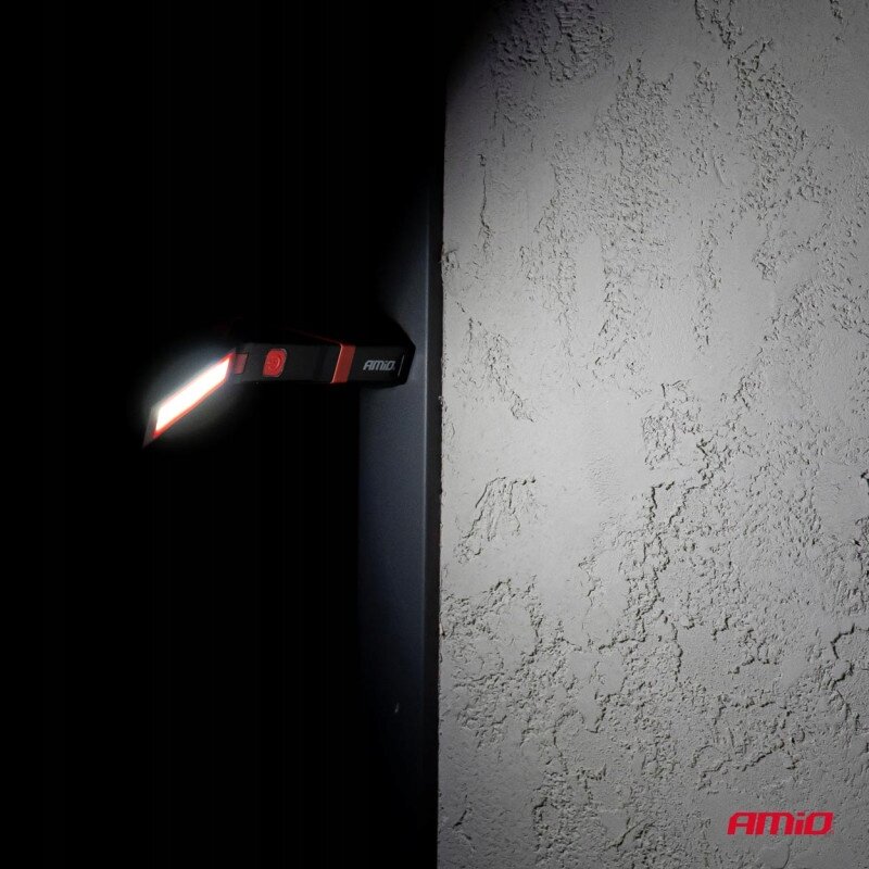 Lampa inspekcyjna AMiO LED Cob z magnesem jest przymocowana do ciemnej powierzchni, emitując jasne światło. Na dole obrazu widoczne jest logo \'AMiO\'.
