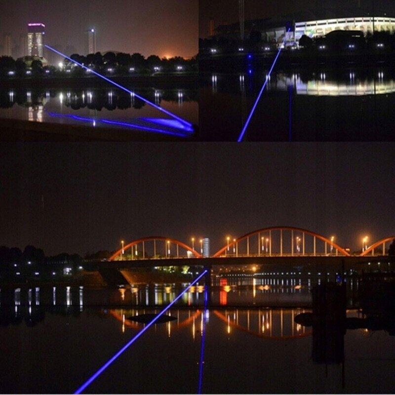 Na zdjęciu widać niebieski promień lasera przecinający nocne niebo nad wodą, odbijający się w jej powierzchni. W tle widoczne są oświetlone budynki i most.