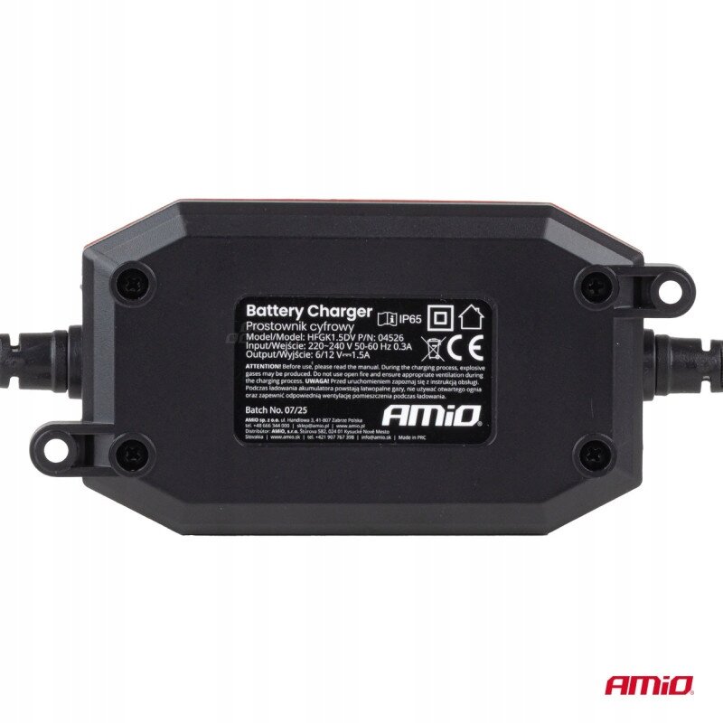 Na obrazie widoczna jest czarna ładowarka do akumulatora z etykietą zawierającą specyfikacje techniczne, takie jak model HFK15DV, wejście 220-240V 50-60Hz 0.3A, wyjście 6/12V 1.5A. W prawym dolnym rogu znajduje się logo \'AMiO\'.