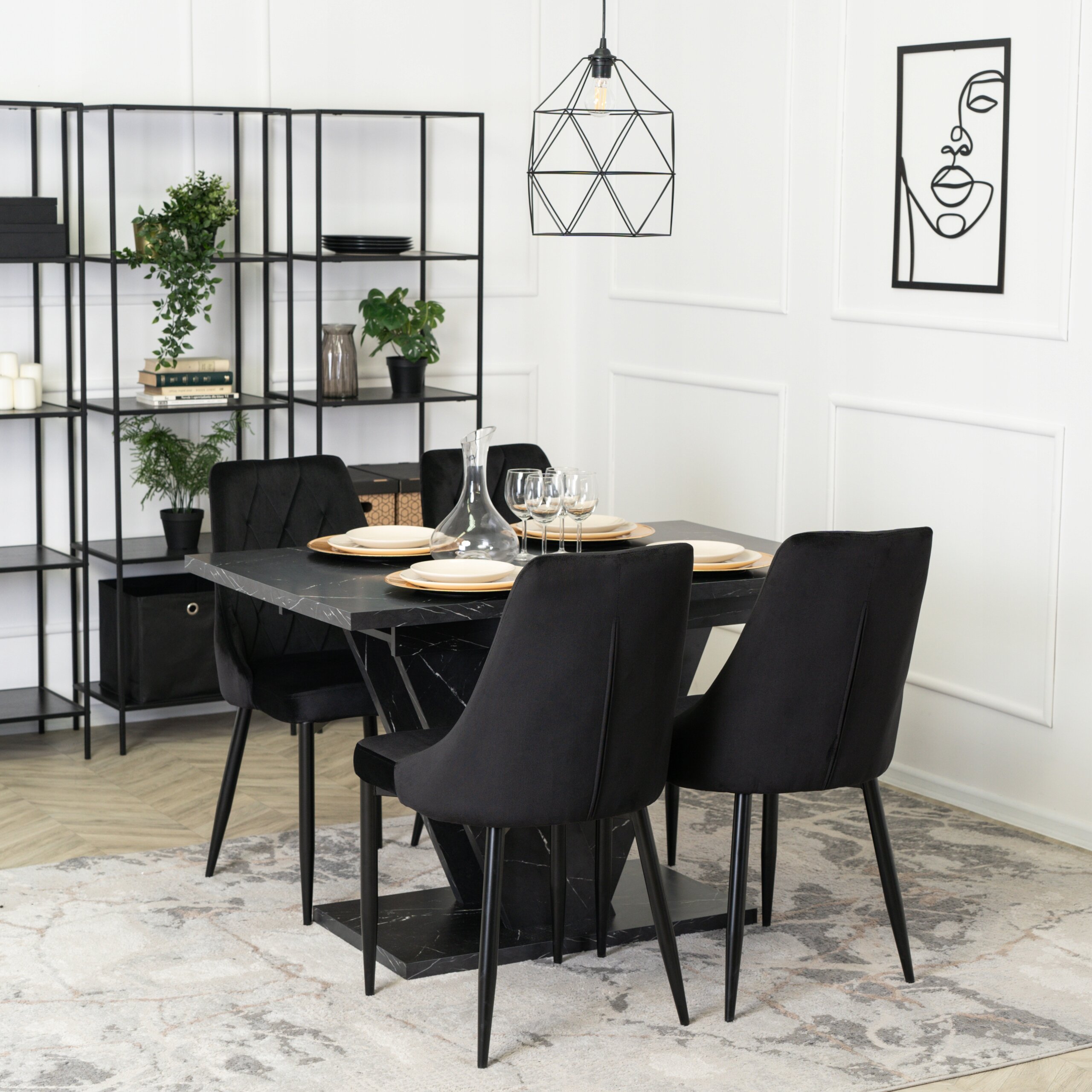 Na obrazie znajduje się czarny rozkładany stół z czterema czarnymi krzesłami w eleganckim wnętrzu. W tle widoczny jest regał z roślinami i dekoracjami oraz minimalistyczny obraz na ścianie.