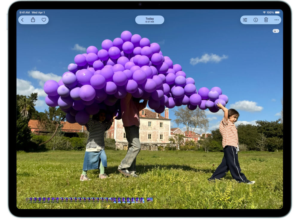 TABLET APPLE IPAD AIR 2026 M4 iPad Air z otwartym zdjęciem dzieci niosących wielką chmurę fioletowych balonów na tle zabytkowego budynku wyświetlacz liquid retina detale jasność odwzorowanie kolorów edycja grafiki wideo