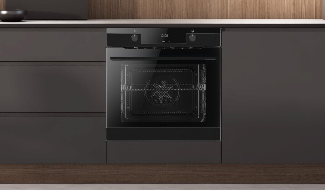 Piekarnik Amica w pozycji zamkniętej w ciemniej zabudowie kuchennej z uchwytami