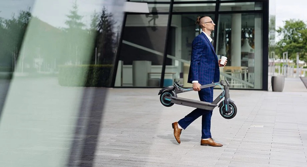 Hulajnoga elektryczna MOTUS Scooty 10 GEN 5 Szary sysem skladania latwy transport bespiezny system skladania wykorzysanie sil przeciwnych wzdgledem siebie haczyk zabezpieczajacy blokuje hulajnoge przed przypadkowym rozlozeniem