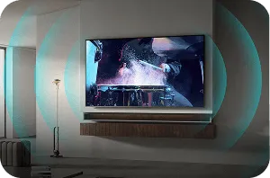 Telewizor zamontowany na ścianie wyświetla dynamiczną scenę z filmu. Wokół ekranu widoczne są efekty świetlne sugerujące dźwięk przestrzenny.