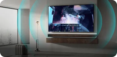 Na ścianie wisi duży telewizor wyświetlający dynamiczną scenę z filmu. W pomieszczeniu znajduje się również lampa stojąca i okno z widokiem na zewnątrz.
