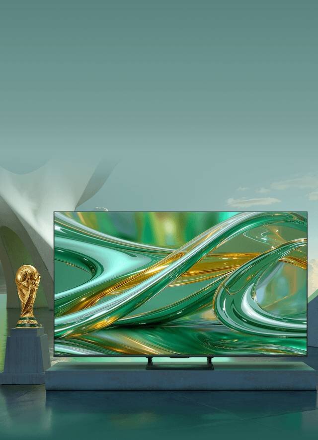 Telewizor z wyświetlaczem pokazującym abstrakcyjne wzory w zielonych i złotych odcieniach. Obok telewizora znajduje się złoty puchar na postumencie.