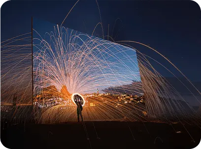 Telewizor Hisense wyświetla postać kręcącą płonącymi iskrami, które płynnie przechodzą poza krawędzie ekranu