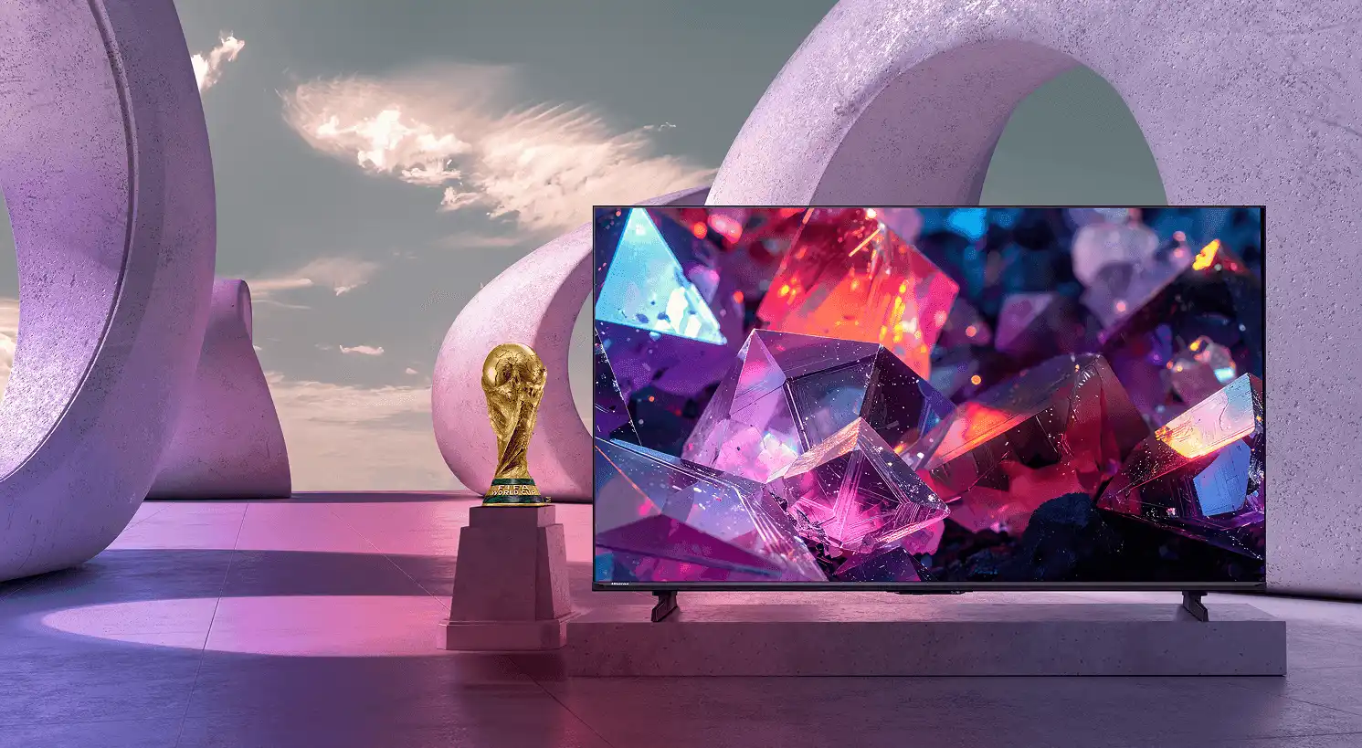 Telewizor Hisense E7 Pro z kolorową grafiką kryształów obok statuetki FIFA World Cup na tle betonowych, owalnych łuków.