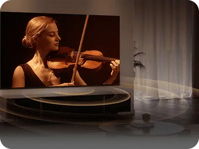 Telewizor z obrazem skrzypaczki na ekranie, z którego rozchodzą się graficzne kręgi ilustrujące dźwięk przestrzenny