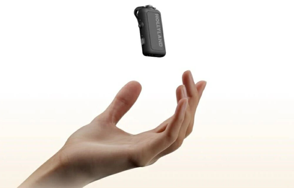 System bezprzewodowy HOLLYLAND Lark Max 2 Ultimate Combo Ręka i unoszący się nadajnik MAX 2 na białym tle z beżową poświatą od dołu waga stabilnie przylega do ubrania wygodne użytkowanie