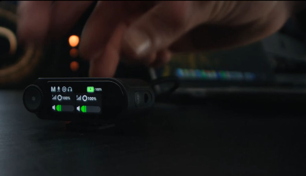 System bezprzewodowy HOLLYLAND Lark Max 2 Ultimate Combo Osoba podłącza odbiornik MAX 2 do laptopa, a na odbiorniku wyświetlają się dwa zielone wskaźniki głośności 8 GB wbudowanej pamięci zapis do 14 godzin bezpieczna kopia zapasowa