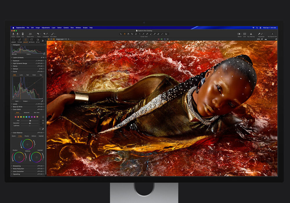 Monitor APPLE Studio Display XDR Profesjonalny monitor z otwartym programem graficznym, na którym edytowane jest artystyczne zdjęcie kobiety w złotej sukni zanurzonej w wodzie o pomarańczowym odcieniu.
