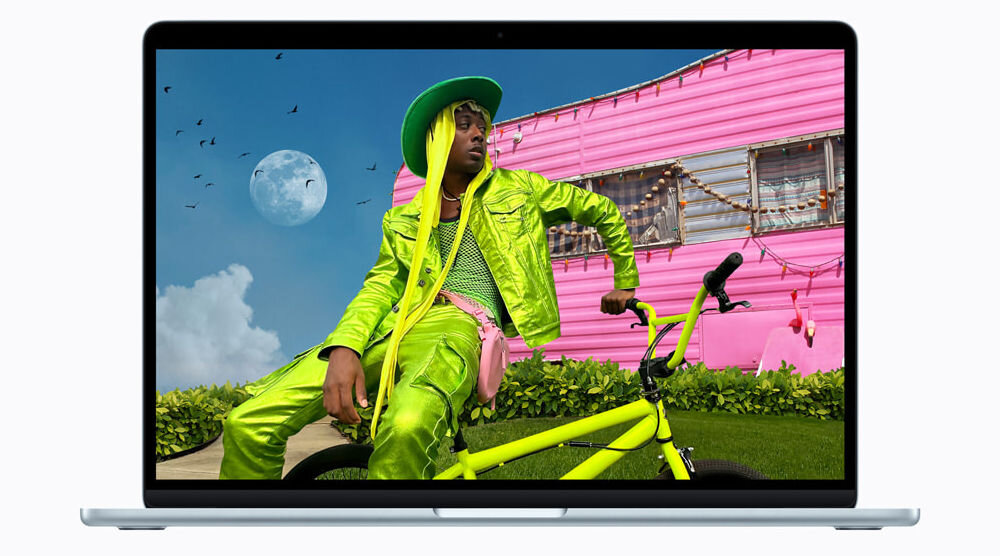 MacBook Air przykładowy obraz z człowiekiem na rowerze Spotlight Liquid Glass Tłumaczenie na żywo