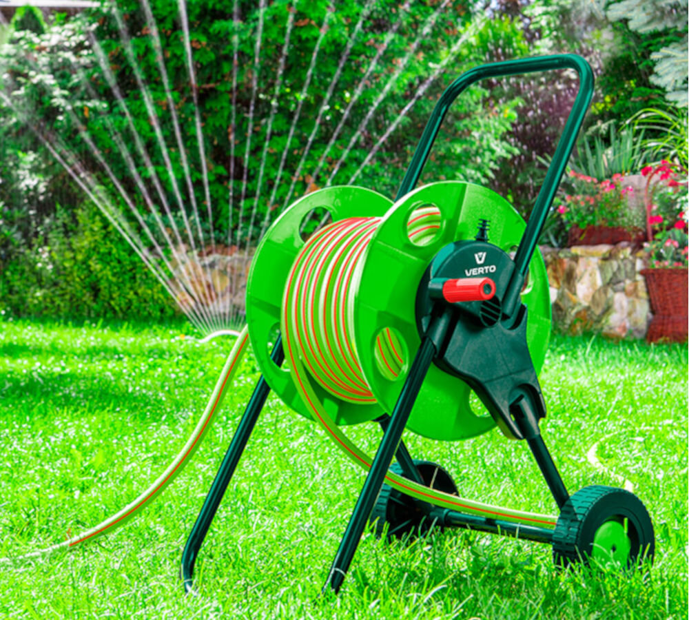 Wąż ogrodowy VERTO Professional 3/4 30 m 15G824, woda, źródło, podlewanie, ogród, w tle zraszacz, na pierwszym planie wąż na transportowej szpuli