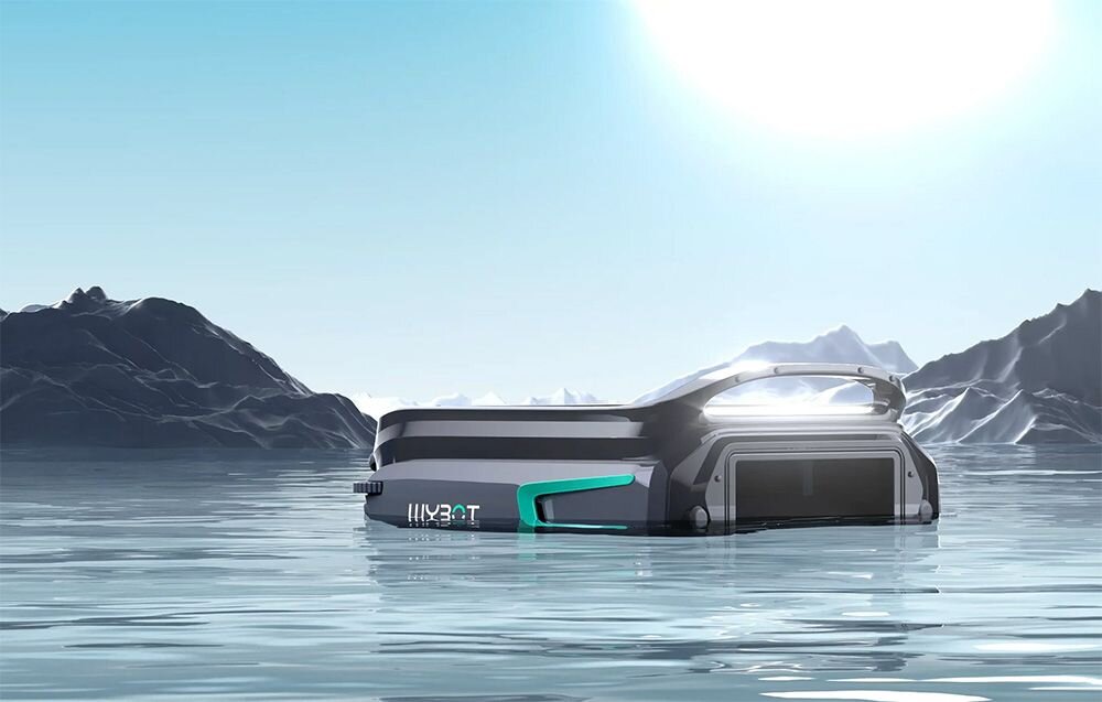 Robot do czyszczenia basenów unosi się na wodzie w otoczeniu górskiego krajobrazu. Na urządzeniu widoczne jest logo \'WYBOT\'.