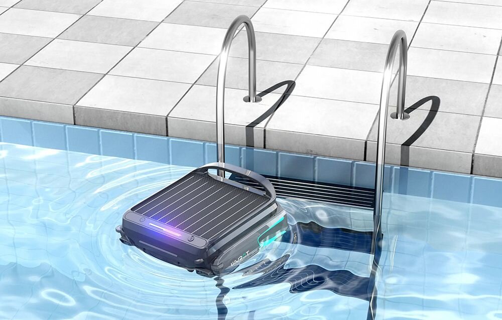 Robot do czyszczenia basenów unosi się na wodzie przy krawędzi basenu, obok metalowej drabinki. Na urządzeniu widoczne są panele i świecące elementy.