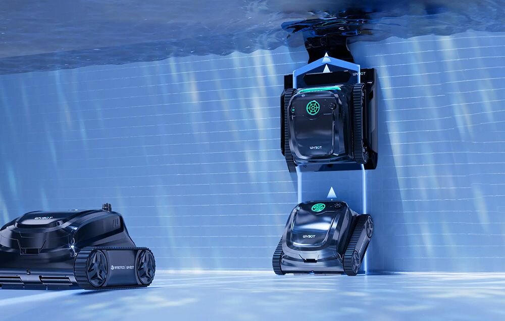 Na obrazie widać trzy roboty do czyszczenia basenów zanurzone w wodzie, z logo \'WYBOT\' na obudowie. Roboty poruszają się po ścianach i dnie basenu, a na jednym z nich widoczny jest symbol przypominający zieloną grafikę.