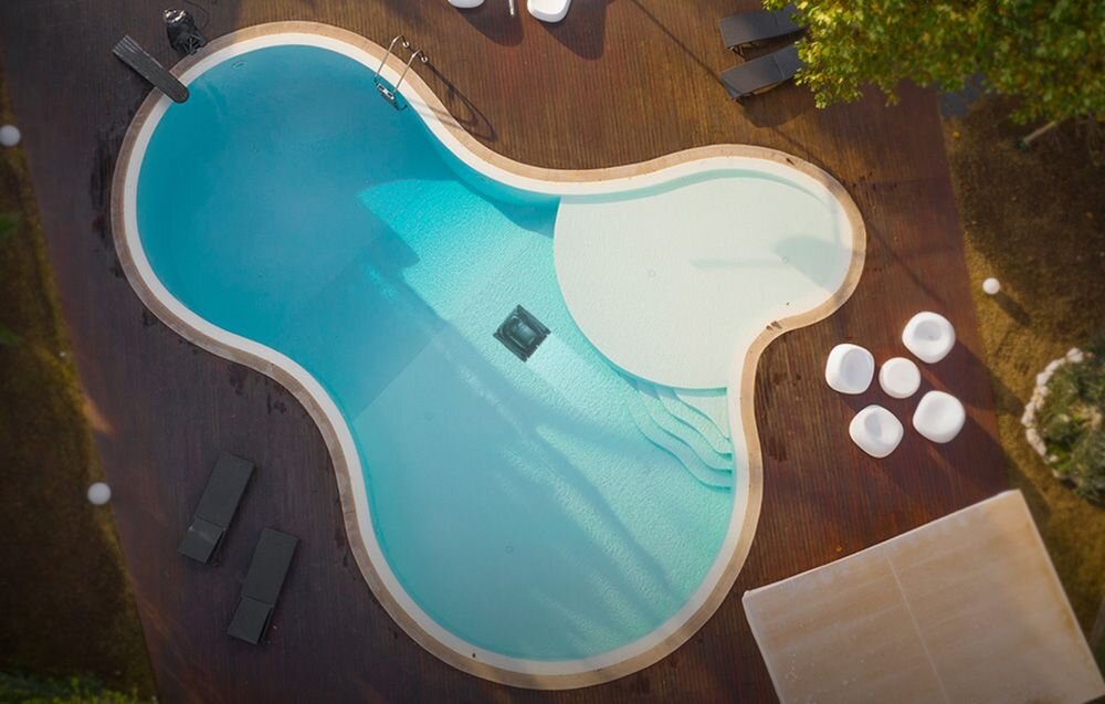 Robot do czyszczenia basenów WYBOT M2, Robot Wybot M2 czyści dno basenu o nieregularnym kształcie, otoczonego drewnianym tarasem, tryby, aplikacja, basen, czyszczenie