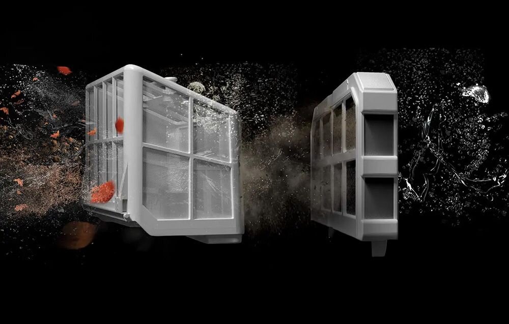 Na obrazie widoczne są dwa białe filtry w kształcie prostokątnych pudełek, przez które przepływa woda z zanieczyszczeniami. W tle widać rozpryskującą się wodę i unoszące się drobinki.