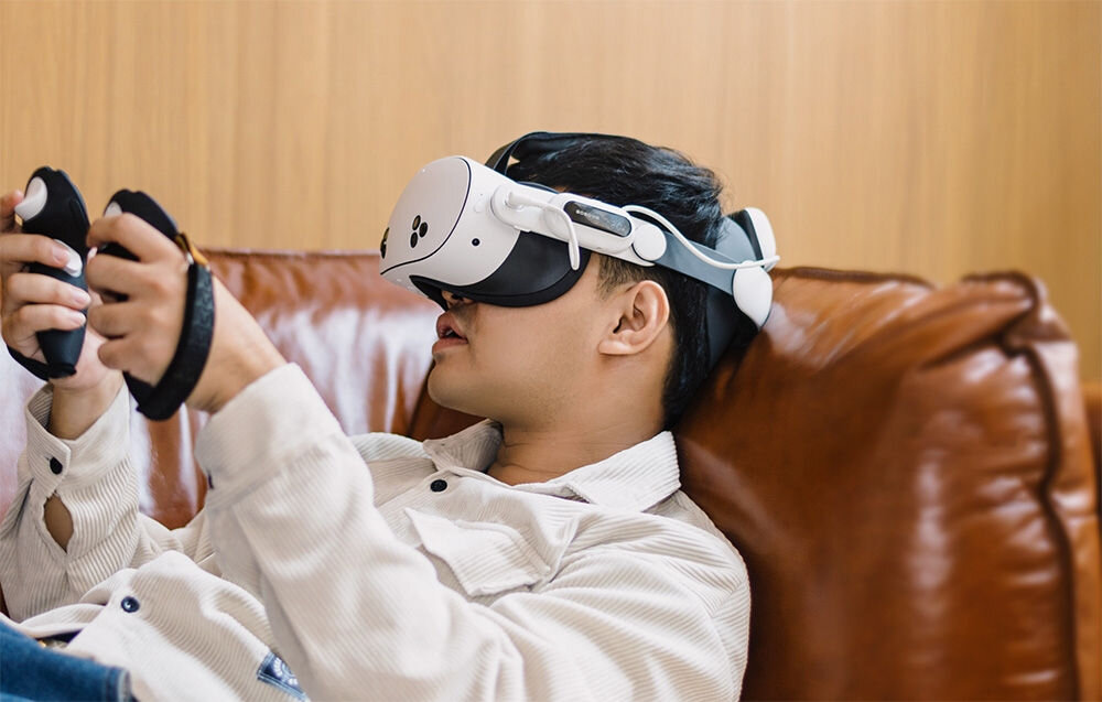 Pasek odciążający BOBOVR E3 PRO do Meta Quest 3/3s + bateria
			pasek założony na głowę leżącego na skórzanej kanapie mężczyzny z goglami VR