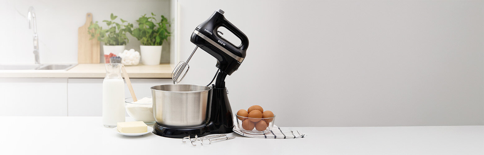 Mikser z misą obrotową MMR-26Z/C na kuchennym blacie, obok składniki na ciasto i para mieszadeł.