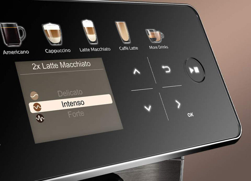 Panel dotykowy ekspresu do kawy z ikonami różnych napojów, takich jak Americano, Cappuccino, Latte Macchiato, Caffè Latte i More Drinks. Wyświetlacz pokazuje opcję \'2x Latte Macchiato\' z wybranym poziomem intensywności \'Intenso\'.