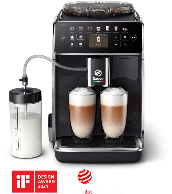 Czarny ekspres do kawy z logo Saeco, z dwoma szklankami wypełnionymi kawą z mleczną pianką. Obok znajduje się pojemnik na mleko, a na dole widoczne są loga nagród iF Design Award 2021 oraz Red Dot Design Award 2021.