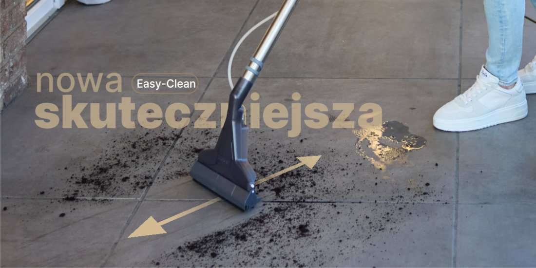Na obrazie widać odkurzacz piorący czyszczący zabrudzoną podłogę. Na podłodze widoczny jest tekst: \'nowa skuteczniejsza Easy-Clean\'.