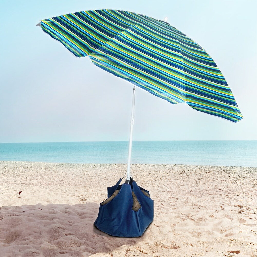 Parasol plażowy z niebiesko-zielonymi paskami stoi na piaszczystej plaży, z widokiem na morze. Podstawa parasola jest wypełniona piaskiem i ma niebieski kolor.