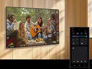 Smartfon Galaxy wyświetla tryb Quick Remote, który służy do zwiększenia głośności pobliskiego telewizora, pokazując scenę kobiety grającej na gitarze.