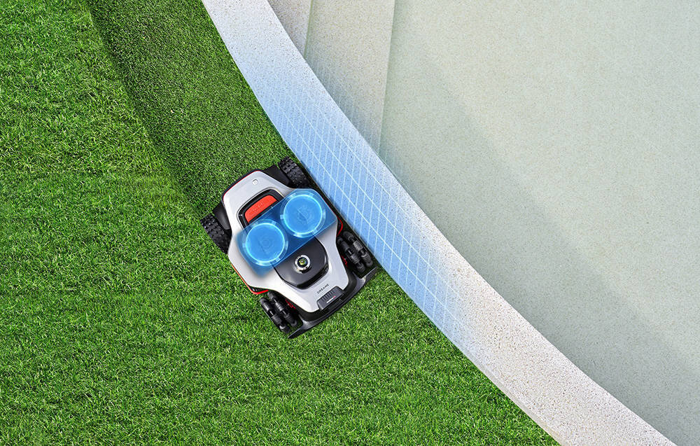 Robot koszący DREAME A3 AWD Pro 5000 trawnik robot kosi trawę wzdłuż ogrodzenia widok z góry na niebiesko zaznaczone ostrza technologia EdgeMaster™ 2.0 skuteczne koszenie przy krawędziach dzięki automatycznemu wysuwaniu tarczy tnącej