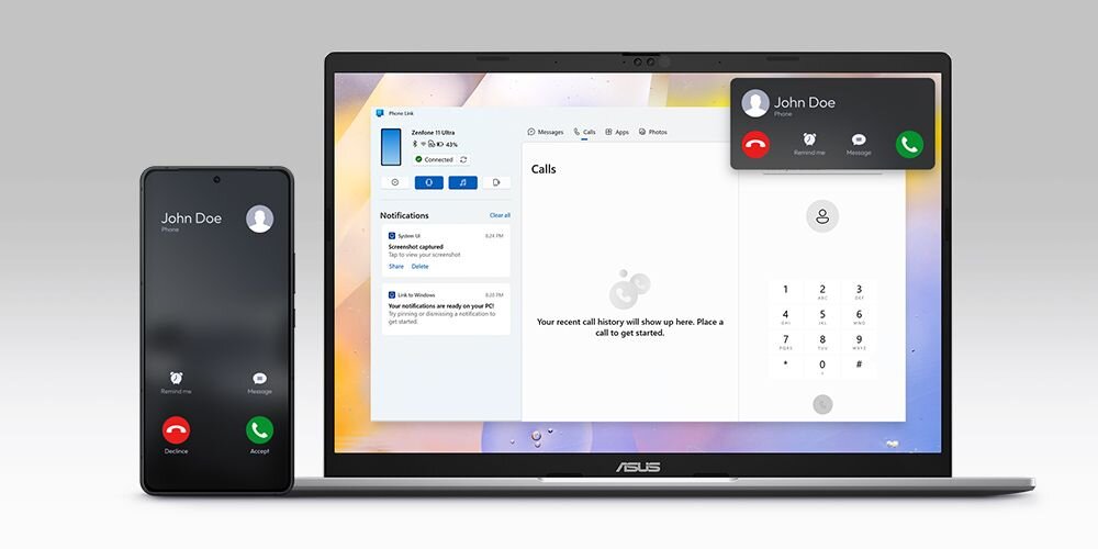 Na obrazie widoczny jest laptop ASUS z otwartym ekranem, na którym wyświetlana jest aplikacja do zarządzania połączeniami telefonicznymi. Obok laptopa znajduje się smartfon z ekranem pokazującym przychodzące połączenie od \'John Doe\'.