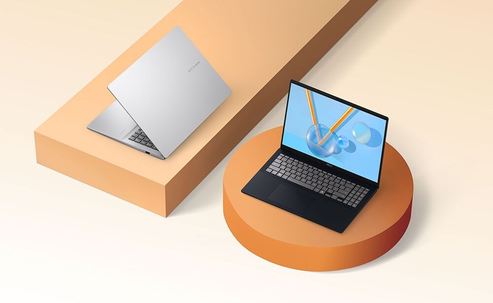Dwa laptopy ASUS VivoBook stoją na geometrycznych podestach, prezentując otwartą i zamkniętą obudowę na jasnym, minimalistycznym tle  