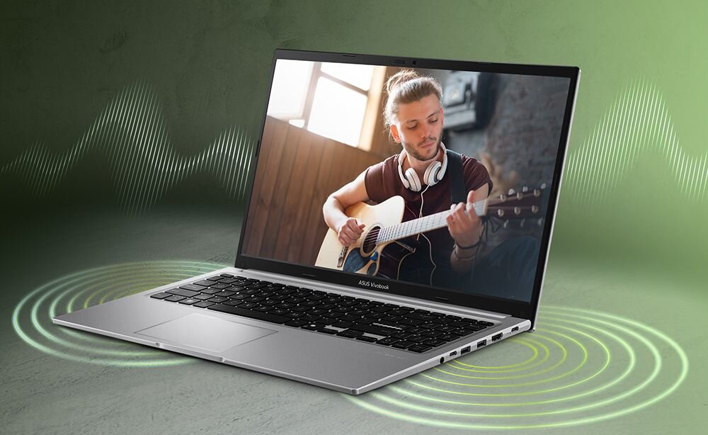 Laptop ASUS Vivobook z otwartym ekranem, na którym widać osobę grającą na gitarze. W tle zielone tło z falami dźwiękowymi, na obudowie widoczne logo \'ASUS Vivobook\'.