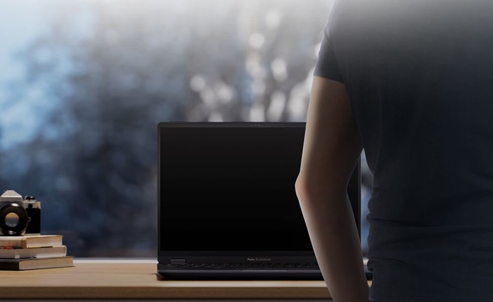 Osoba stoi przed laptopem ASUS Vivobook 14 Flip TP3407SA-SG142W z funkcją Adaptive Lock przy biurku w domowym środowisku pracy