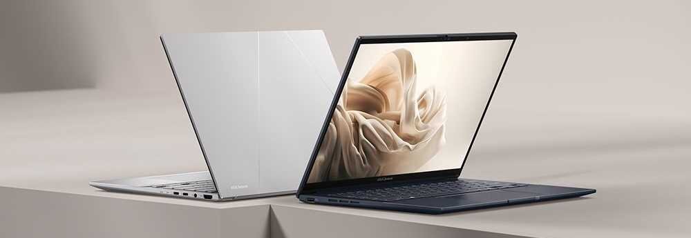Dwa laptopy ustawione na powierzchni, jeden otwarty z widocznym ekranem wyświetlającym abstrakcyjny wzór, drugi zamknięty z widocznym logo ASUS. Oba urządzenia mają elegancki, nowoczesny design.