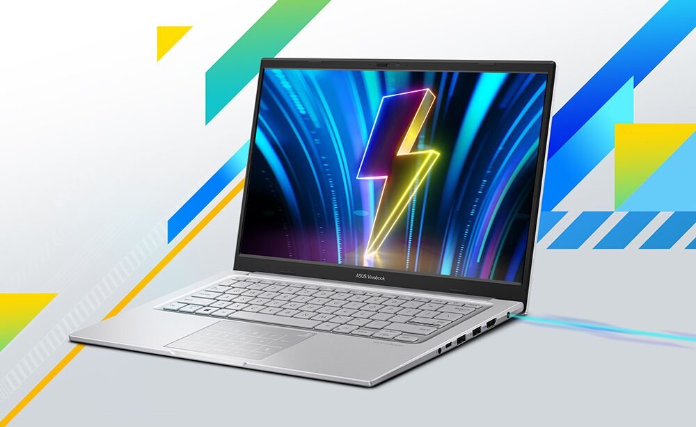 Laptop ASUS Vivobook z wyświetlaczem pokazującym kolorowy błyskawicowy symbol na tle niebieskich i fioletowych promieni. Obudowa jest srebrna, a na dolnej ramce ekranu widnieje napis \'ASUS Vivobook\'.