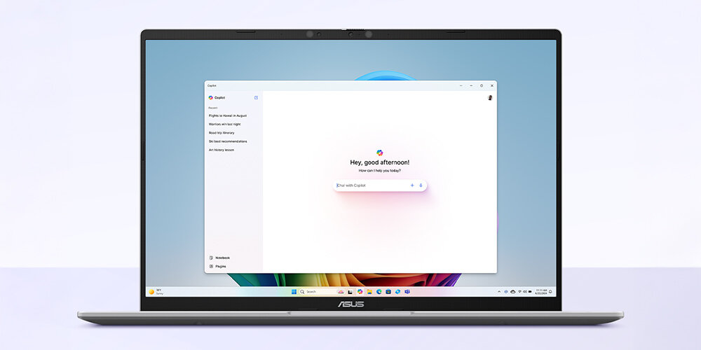 Laptop z widocznym ekranem, na którym wyświetlony jest interfejs systemu operacyjnego z napisem \'Hey, good afternoon!\'. Na dolnej ramce ekranu znajduje się logo \'ASUS\'.