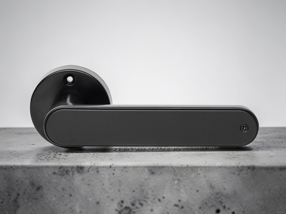 Klamka PSG Luma 63.821 Czarny, PIN, odcisk, karta, Bluetooth, Czarna klamka inteligentna na tle betonowej powierzchni 