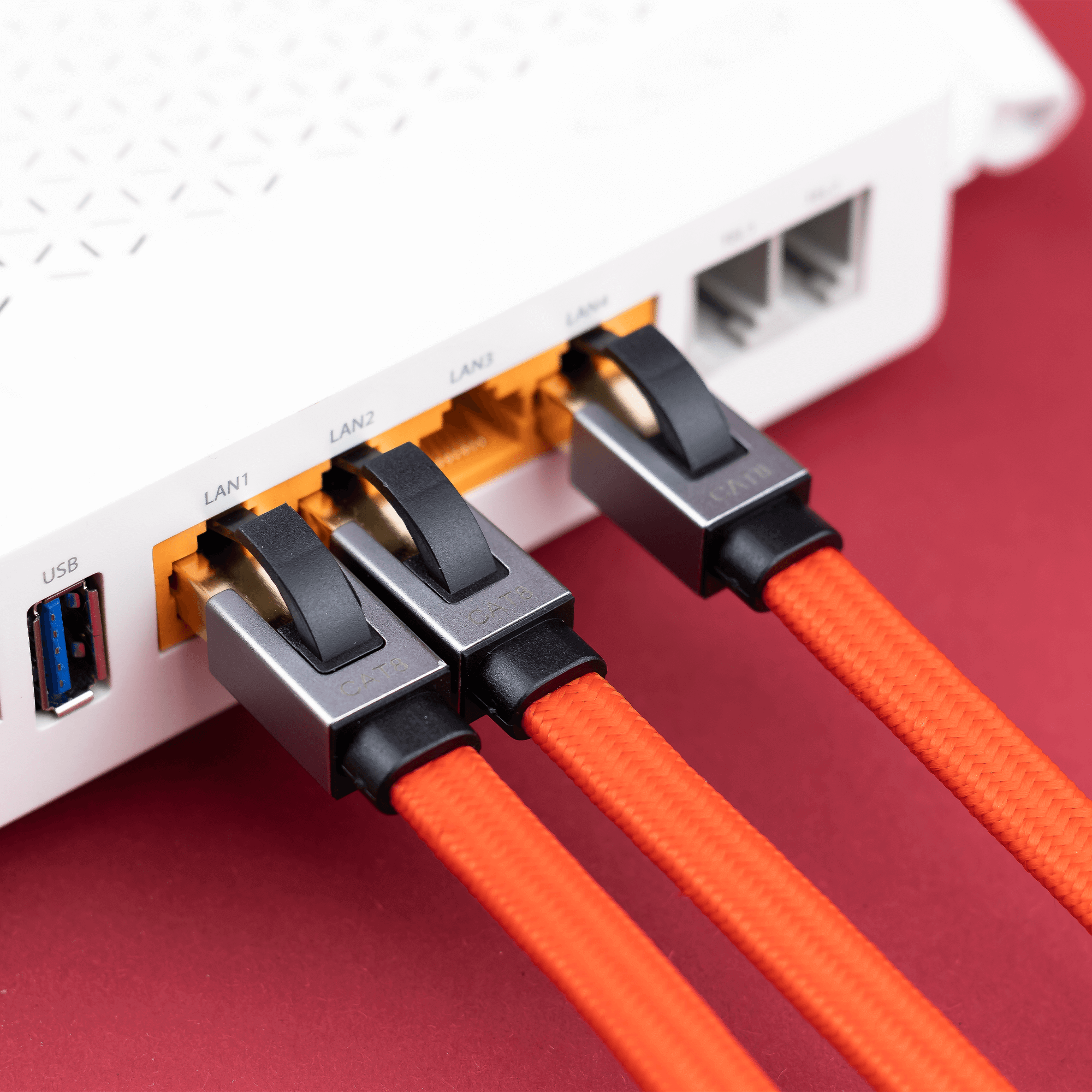 Na obrazie widoczny jest biały router z trzema podłączonymi pomarańczowymi kablami Ethernet do portów LAN1, LAN2 i LAN3. Obok portów LAN znajduje się port USB oraz dwa puste porty LAN4 i LAN5.